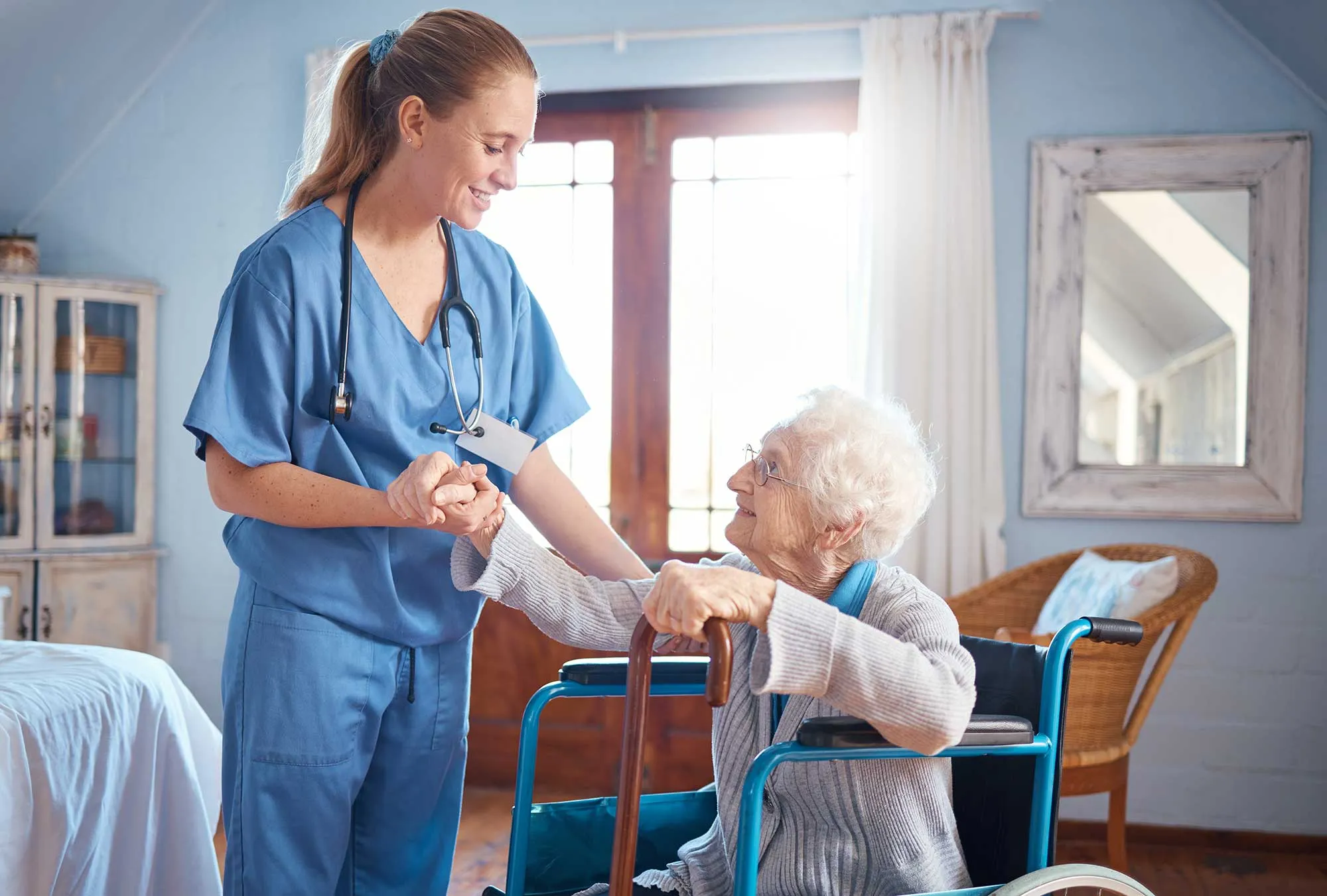 Senior patient holding hands with nurse